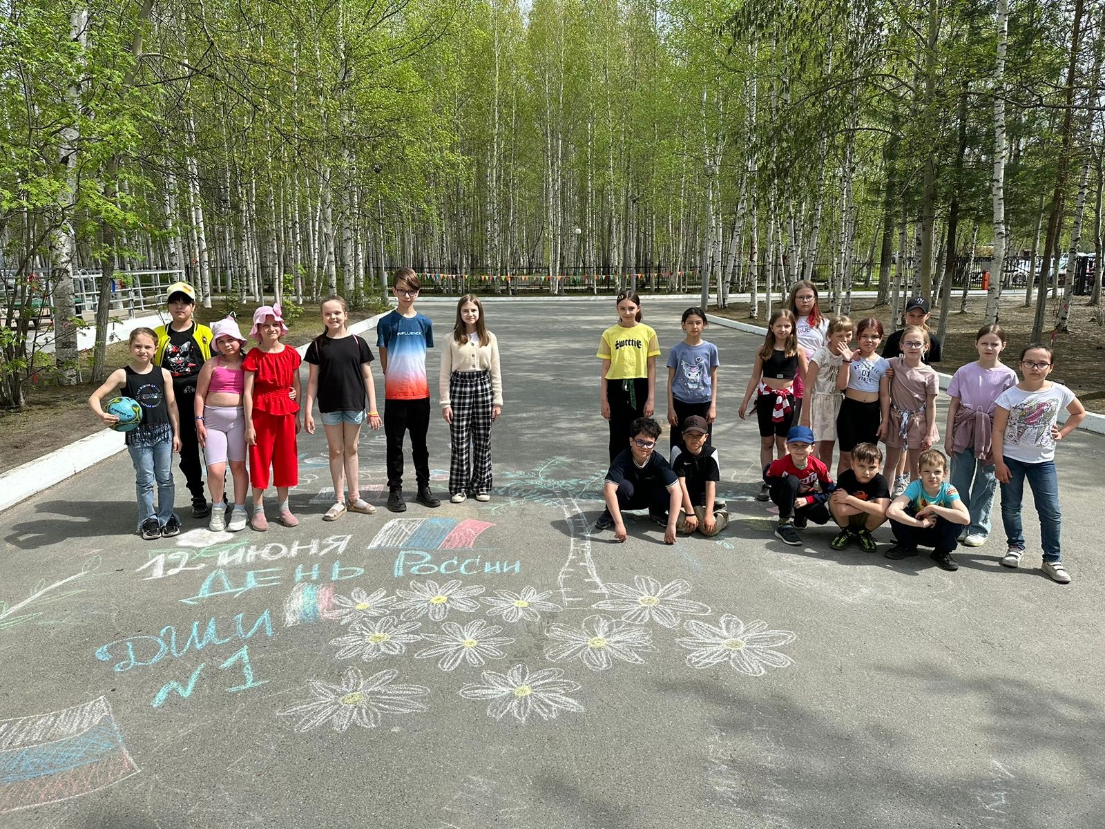 На фото: Воспитанники лагеря рисуют на асфальте